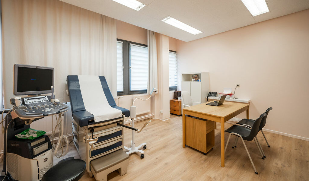 Salle de consultation de gynécologie-obstétrique de la Polyclinique de Fléron, avec échographe et table d'examen