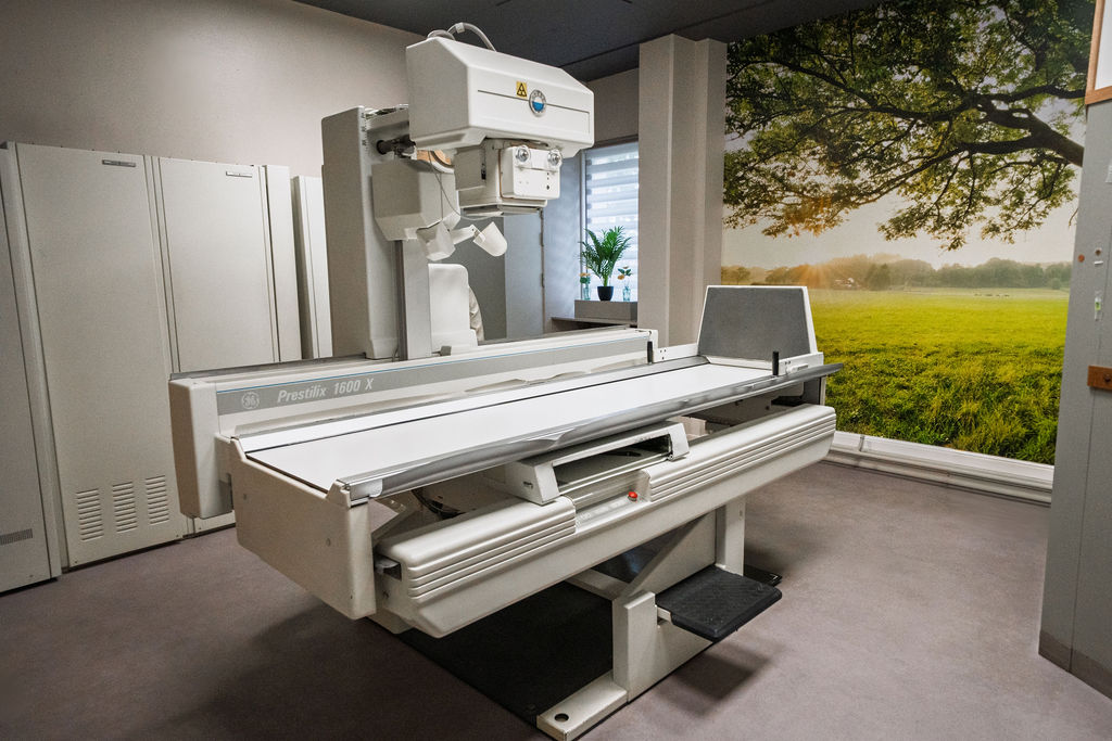 Salle de radiologie de la Polyclinique de Fléron, avec table d'examen et appareil de radiographie